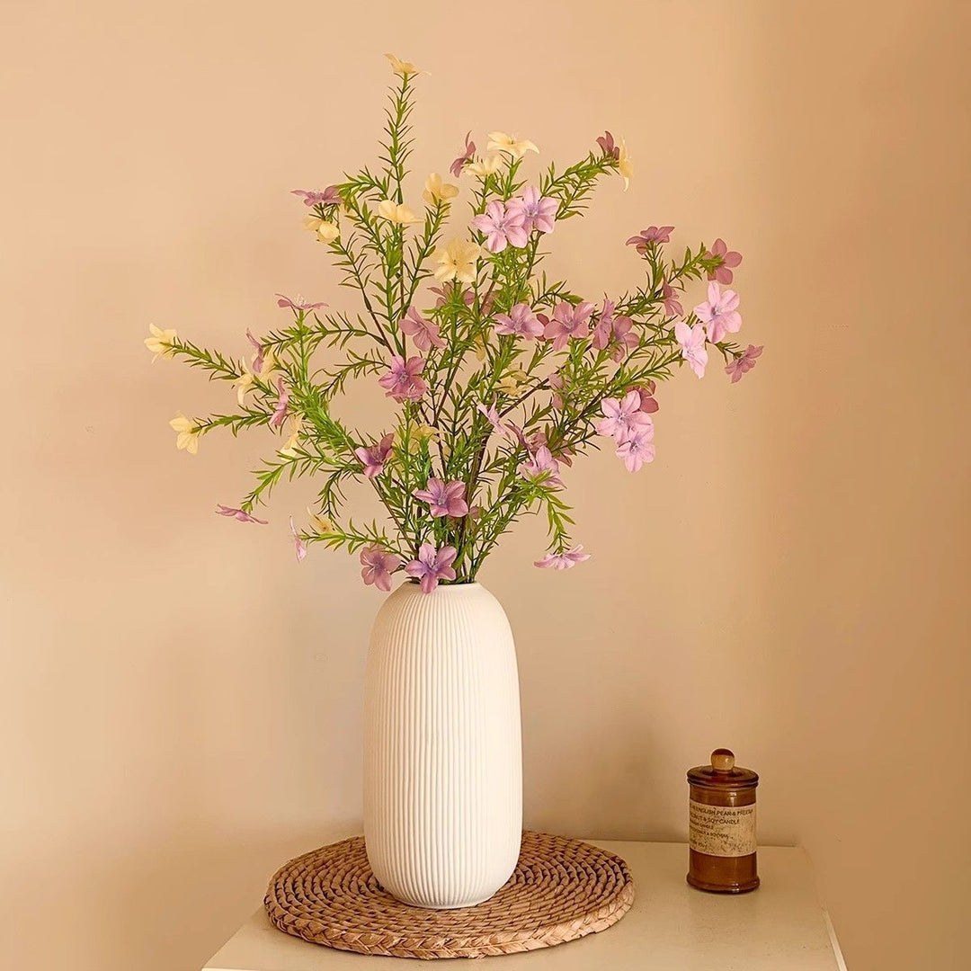 levensechte bloemstuk met elegante vaas