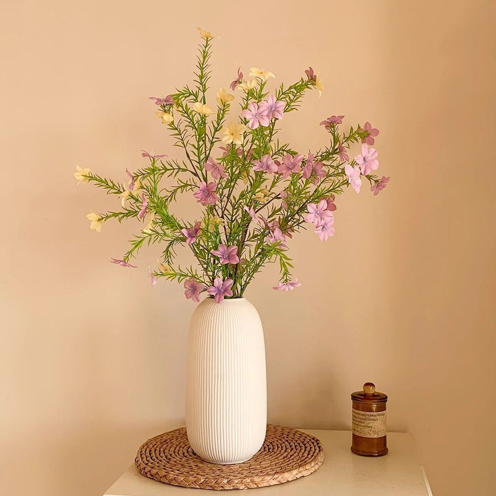 levensechte bloemstuk met elegante vaas